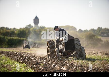 Alte und alte fordson Tractorr, die mit einem Pflug auf den Feldern arbeiten und zeigen, wie die Landwirtschaft vor vielen Jahren erfolgte. Stockfoto