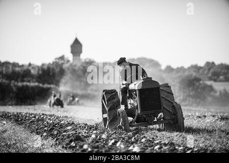 Alte und alte fordson Tractorr, die mit einem Pflug auf den Feldern arbeiten und zeigen, wie die Landwirtschaft vor vielen Jahren erfolgte. Stockfoto