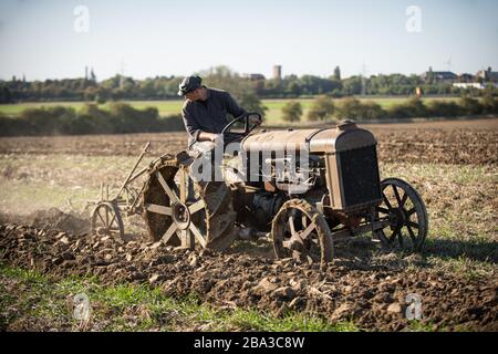 Alte und alte fordson Tractorr, die mit einem Pflug auf den Feldern arbeiten und zeigen, wie die Landwirtschaft vor vielen Jahren erfolgte. Stockfoto