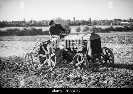 Alte und alte fordson Tractorr, die mit einem Pflug auf den Feldern arbeiten und zeigen, wie die Landwirtschaft vor vielen Jahren erfolgte. Stockfoto