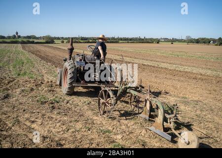 Der alte und alte Lanz Bulldog Tractorr, der mit einem Pflug auf den Feldern arbeitet und zeigt, wie die Landwirtschaft vor vielen Jahren erfolgte. Stockfoto