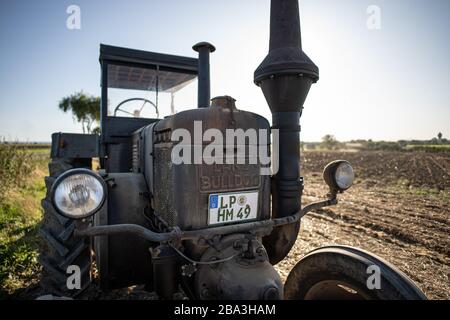 Der alte und alte Lanz Bulldog Tractorr, der mit einem Pflug auf den Feldern arbeitet und zeigt, wie die Landwirtschaft vor vielen Jahren erfolgte. Stockfoto