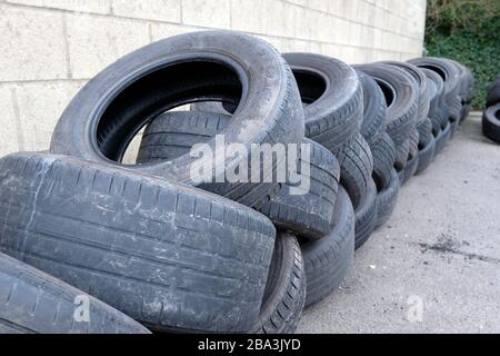 Februar 2020 - alte Reifen stapelten sich bereit für das Recycling vor einer Garage im Somerset Dorf Cheddar. Stockfoto
