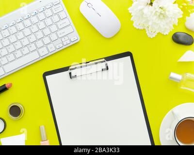 Tastatur Maus, Tasse Tee und Makeup Werkzeuge und Kosmetikprodukte um sie herum isoliert auf einem kalkgrünen Farbhintergrund. Flaches Layout, Kopierbereich in der Draufsicht. Stockfoto