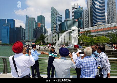 Touristen, die vor der Merlion-Statue, dem Marina Bay Reservoir, Singapur, Bilder von sich machen Stockfoto