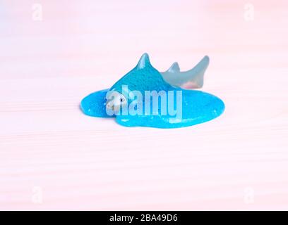Toy Shark ertränkt sich in einem blauen Schleim. Weltweites, trendy Spielzeug. Stockfoto