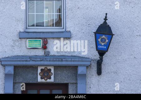 Ein Gardai-Siochana-Wappen und eine Gardai-Polizeidienstleuchte über dem Eingang zu einer ländlichen Polizeistation in Irland bei Kerrykeel, County Donegal. Stockfoto