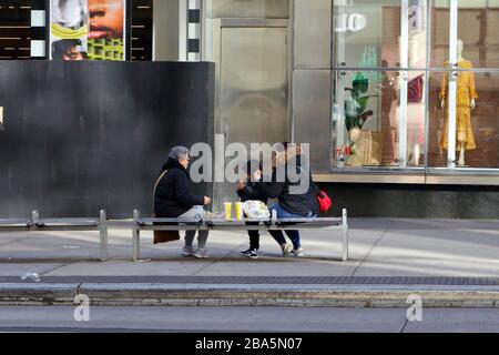 New York, New York, 24. März 2020. Während der Coronavirus-COVID-19-Pandemie diniert eine Familie draußen auf einer Bank in Manhattans Upper East Side. Eine vom Gouverneur des Staates New York erlassene Anordnung hat Restaurants und Bars untersagt, Kunden zu bedienen, außer nur für Abfern- und Lieferaufträge. Kredit: Robert K. Chin. Stockfoto