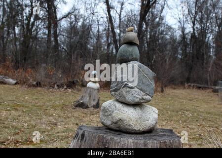 Nahaufnahme EINES Rock Stacks auf EINEM Stump, ein weiterer Rock Pile im Vordergrund Stockfoto