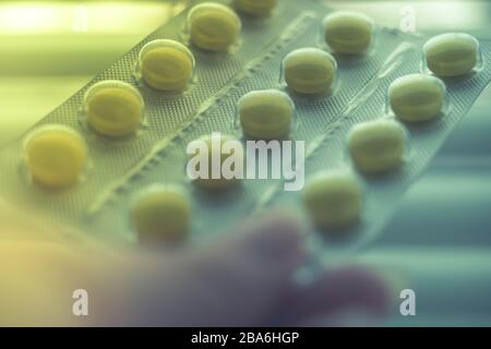 Blister mit Vitaminen oder Pillen in weiblichen Fingern in Nahaufnahme Stockfoto