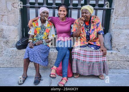 Tourist und zwei kubanische Frauen, die eine Zigarre rauchen, Havanna, Kuba Stockfoto