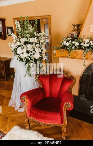 Speziell eingerichtetes Wohnzimmer. Sessel, Kamin und Blumen Stockfoto
