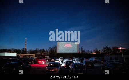 Essen, Deutschland. März 2020. Autos stehen im Sonnenuntergang auf dem Hügel. Das Drive-In-Kino ist auch während der Corona-Pandemie geöffnet. Besucher müssen Tickets online buchen, da es keine Abendkasse mehr gibt. Auch dürfen nur zwei Personen in einem Auto sitzen, Kinder ausgeschlossen. Kredit: Fabian Strauch / dpa / Alamy Live News Stockfoto