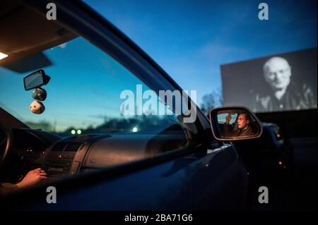 Essen, Deutschland. März 2020. Ein Besucher ist im Seitenspiegel seines Autos zu sehen. Das Drive-In-Kino ist auch während der Corona-Pandemie geöffnet. Besucher müssen Tickets online buchen, da es keine Abendkasse mehr gibt. Auch dürfen nur zwei Personen in einem Auto sitzen, ohne Kinder. Kredit: Fabian Strauch / dpa / Alamy Live News Stockfoto