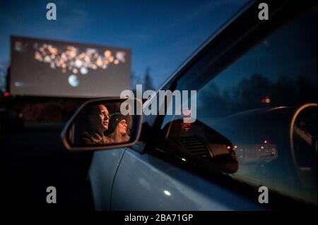 Essen, Deutschland. März 2020. Zwei Besucher des Drive-In-Kinos sitzen im Auto und schauen auf die Leinwand. Das Kino ist auch während der Corona-Pandemie geöffnet. Besucher müssen Tickets online buchen, da es keine Abendkasse mehr gibt. Auch dürfen nur zwei Personen in einem Auto sitzen, Kinder ausgeschlossen. Kredit: Fabian Strauch / dpa / Alamy Live News Stockfoto