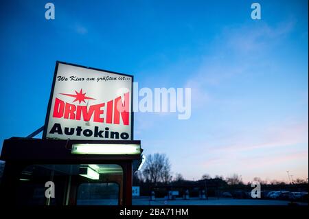 Essen, Deutschland. März 2020. Das Schild des Drive-in Drive-in-Kinos leuchtet bei Sonnenuntergang am Eingang. Das Drive-In-Kino ist auch während der Corona-Pandemie geöffnet. Besucher müssen Tickets online buchen, da es keine Abendkasse mehr gibt. Auch sind nur zwei Personen in einem Auto erlaubt, ausgenommen Kinder. Kredit: Fabian Strauch / dpa / Alamy Live News Stockfoto