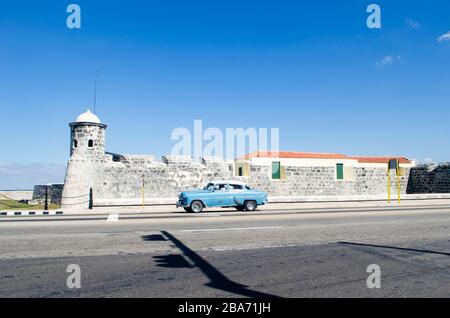 Blick auf die Landschaft der Festung Salvador de la Punta. Ein blauer Oldtimer fährt auf der Straße Stockfoto