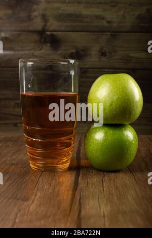 Grüne Äpfel und ein Glas Saft Stockfoto