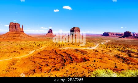Die Schotterstraße kurvt um mitten Buttes, Merrick Butte und andere große Sandsteinformationen im Monument Valley Navajo Tribal Park im Süden der USA Stockfoto