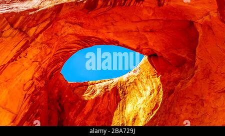 The Sun's Eye, ein Loch in der Decke einer großen Sandsteinformation, im Monument Valley Navajo Tribal Park an der Grenze zu Utah und Arizona, USA Stockfoto