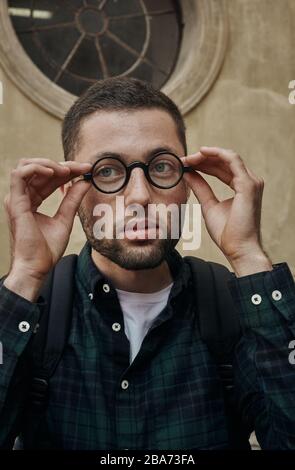 Porträt eines schönen jungen Mannes in einer klassischen runden Brille Stockfoto