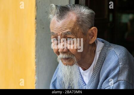 Der alte Vietnamese in der Türöffnung Stockfoto