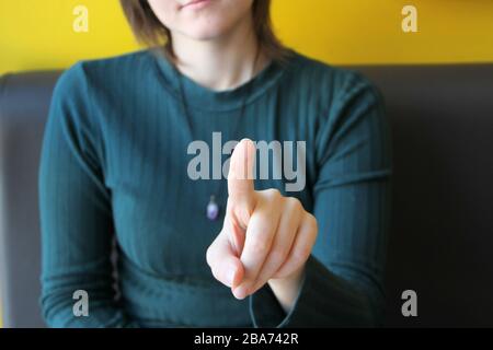 Mädchen hält Zeigefinger vor sich, zeigt auf Zuschauer und Kamera. Stockfoto