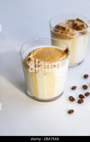 Südkoreanischer Kaffee Dalgona - trendige kalte Latte oder Cappuccino mit Milch und Rohrzucker. Sommergetränk zum Frühstück Stockfoto