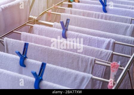 Weisses Handtuch an der Wäscheleine am sonnigen Tag. Stockfoto