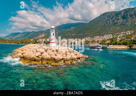 Leuchtturm an einem sonnigen Morgen mit Fischerbooten am Hafen von Kas Türkei Stockfoto