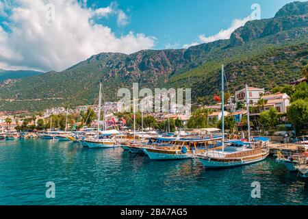 Leuchtturm an einem sonnigen Morgen mit Fischerbooten am Hafen von Kas Türkei Stockfoto
