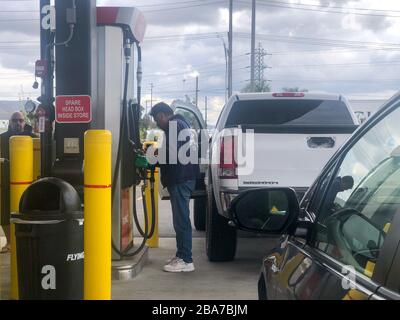 Ein Mann fügt seine Karte ein, bevor er seinen GMC Sierra Truck in einer Flying J Travel Center-Tankstelle auffüllte, wo Gas am Mittwoch, 25. März 2020, in Jurupa Valley, Kalifornien, USA, einen Tiefpunkt von 1,79 Dollar erreichte. (Foto von IOS/Espa-Images) Stockfoto