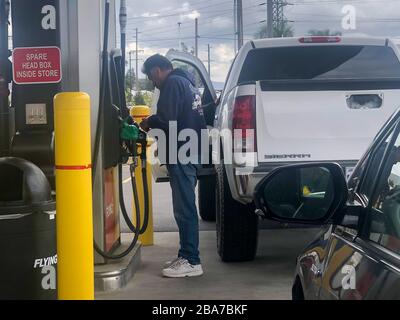 Ein Mann fügt seine Karte ein, bevor er seinen GMC Sierra Truck in einer Flying J Travel Center-Tankstelle auffüllte, wo Gas am Mittwoch, 25. März 2020, in Jurupa Valley, Kalifornien, USA, einen Tiefpunkt von 1,79 Dollar erreichte. (Foto von IOS/Espa-Images) Stockfoto