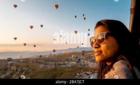 Mädchen im Urlaub in Kappadokien Türkei Sonnenaufgang in den Hügeln mit Heißluftballons, Kapadokya schöne bunte Luftballons in Sonnenaufgang Licht in Stockfoto