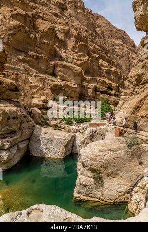 Wadi Shab, Oman. Touristen, die auf den wegen, Flüssen und Pools des Wadi wandern, schwimmen und sonnen. Stockfoto