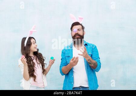Ei jonglieren. Spaß bei der Ostereierjagd. Fröhliche Familie bereitet sich auf Ostern vor. Glückliche Familienzeit. Vater und Tochter feiern Ostern. Lächelnd und lachend. Kaninchenparty. Feiertag vorbereiten. Stockfoto