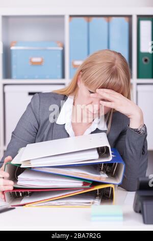 Überforderte Frau im Büro. Überarbeitetes, Burnout- und Stresskonzept. Stockfoto