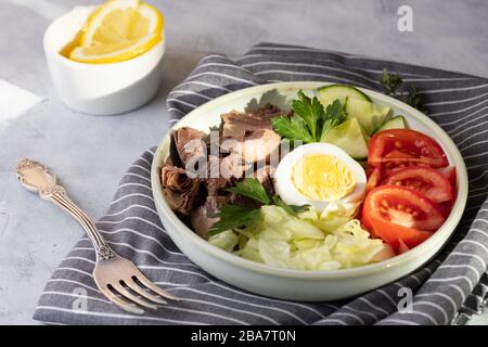 Salat mit Thunfisch, Ei und Gemüse - Tomaten, Gurken und Salat. Stockfoto