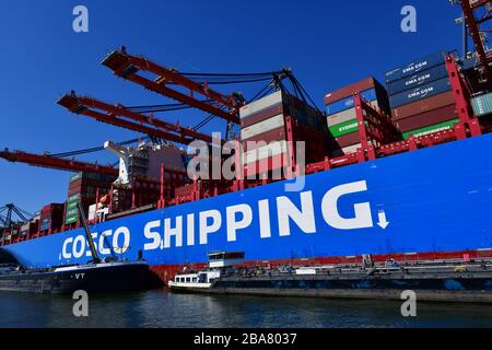 Rotterdam, die Niederlande-August 2019; Tiefwinkelansicht des Mittelschiffabschnitts des Containerschiffs, "von Land zu Land" im Terminal mit Portalkränen risin Stockfoto