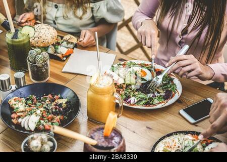 Blick auf junge Leute, die Brunch und Smoothies mit ökologischen Strohhalmen im kunststofffreien Restaurant essen - gesunder Lebensstil, Lebensmitteltrend Stockfoto