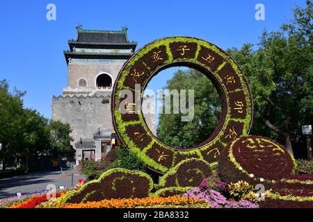 Peking, China-Oktober 2019; Glocken- und Trommelturm mit in vorderster Reihe großer Blumenarrangement in Form eines Kreises Stockfoto