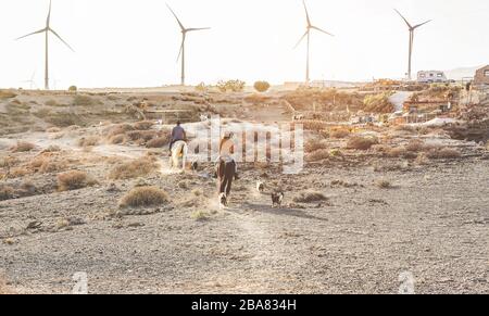 Junge Leute, die Pferde reiten, die einen Ausflug bei Sonnenuntergang machen - Wild Couple hat Spaß auf der Reitranch - Training, Kultur, Leidenschaft, gesunder Lebensstil, sp Stockfoto