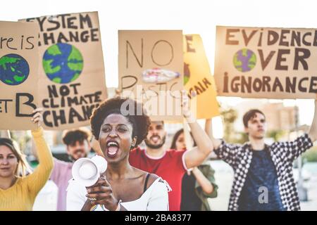 Eine Gruppe junger Demonstranten auf der Straße, junge Menschen aus verschiedenen Kulturen und Rassen kämpfen für die plastische Verschmutzung und den Klimawandel - die globale Erwärmung und Stockfoto