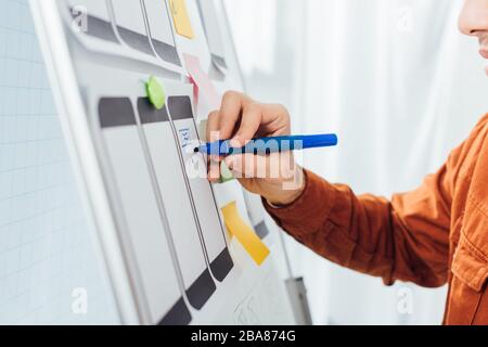 Zugeschnittene Ansicht des Entwicklers mit Marker Planning ux-Design der mobilen Website mit Vorlagen auf Whiteboard Stockfoto