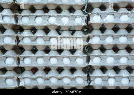 Auf dem Markt werden Hühnereier auf dem Tablett zum Verkauf angeboten, EIN Haufen Eier in Papiertafeln. Stockfoto