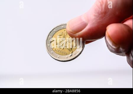 Euro-Münzen-Crowon-Seite in menschlicher Hand für Zahlung auf weißem Hintergrund mit Kopierraum Stockfoto