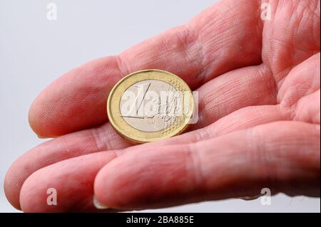 Eine Euro-Münze Rückseite in menschlicher Hand für Zahlung auf weißem Hintergrund mit Kopierraum Stockfoto