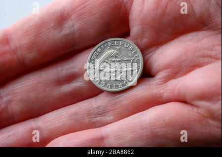 Portugiesische Reis Coin Rückseite in menschlicher Hand für Zahlung auf weißem Hintergrund mit Kopierraum Stockfoto