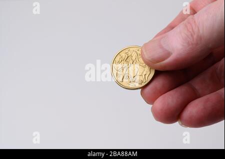 Australische Dollar-Münze Rückseite in menschlicher Hand für Zahlung auf weißem, einfachem Hintergrund mit Kopierraum Stockfoto