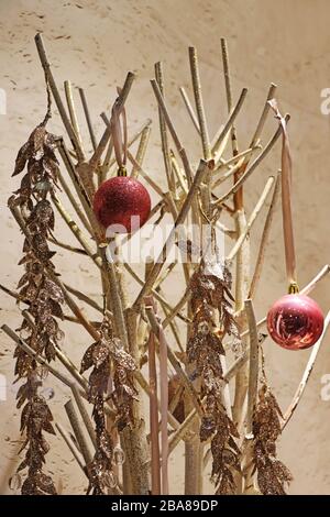 Zwei rote weihnachtskugeln auf goldenen Zweigen als Dekoration Stockfoto